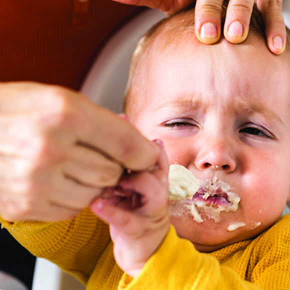 Caregiver offering food to a baby