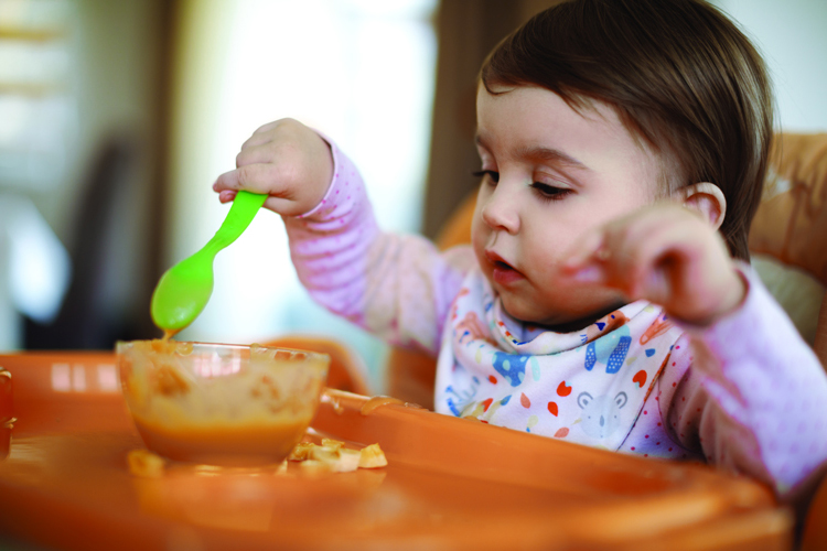 Baby sitting in a high chair with food