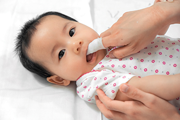 Infant lying on back and looking toward caregiver